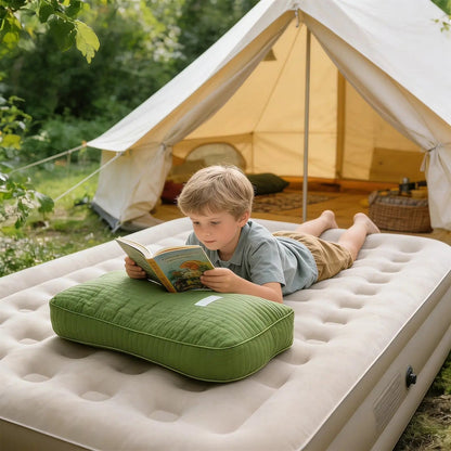 Child reading on a buckwheat pillow on an air mattress outdoors