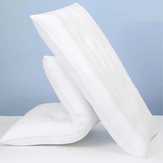 Two white low loft cotton pillows leaning against each other
